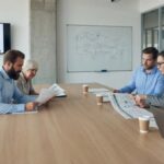 Business team reviewing performance charts and network diagrams together during a strategy meeting